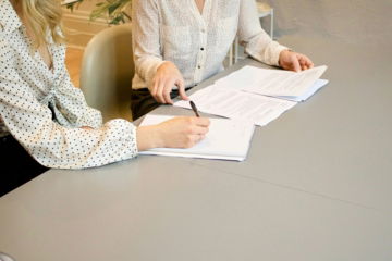 woman-signing-on-white-printer-paper-beside-woman-about-to-touch-the-documents.jpg woman signing on white printer paper beside woman about to touch the documents